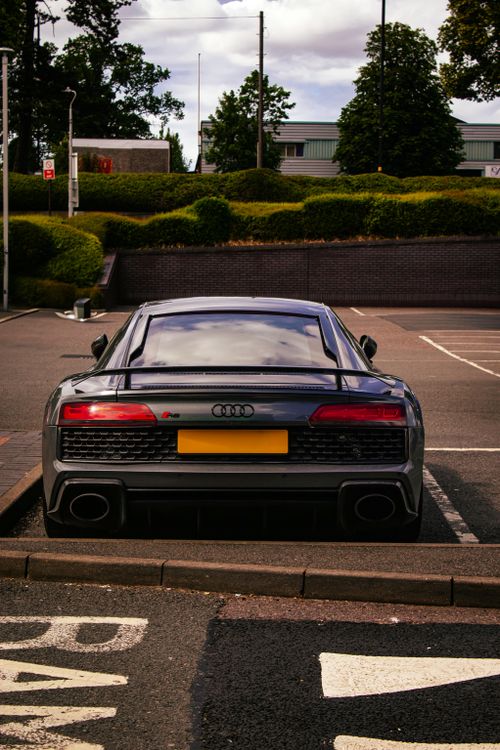 Free Rear view of a gray Audi R8 parked in a Birmingham urban lot on a clear day, showcasing the car's design. Stock Photo