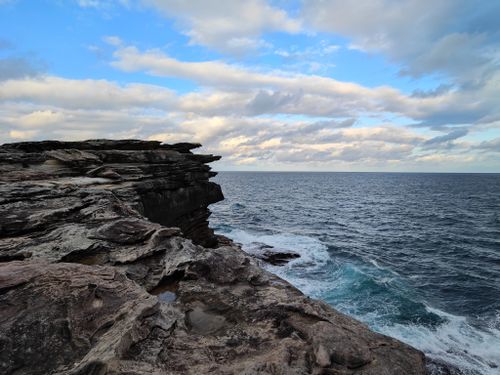 Free Breathtaking sandstone cliffs meet the ocean at Clovelly Beach in New South Wales, Australia. Stock Photo