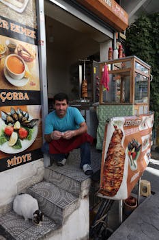 Street food vendor at a local Istanbul eatery with doner kebab and vibrant menu signage.