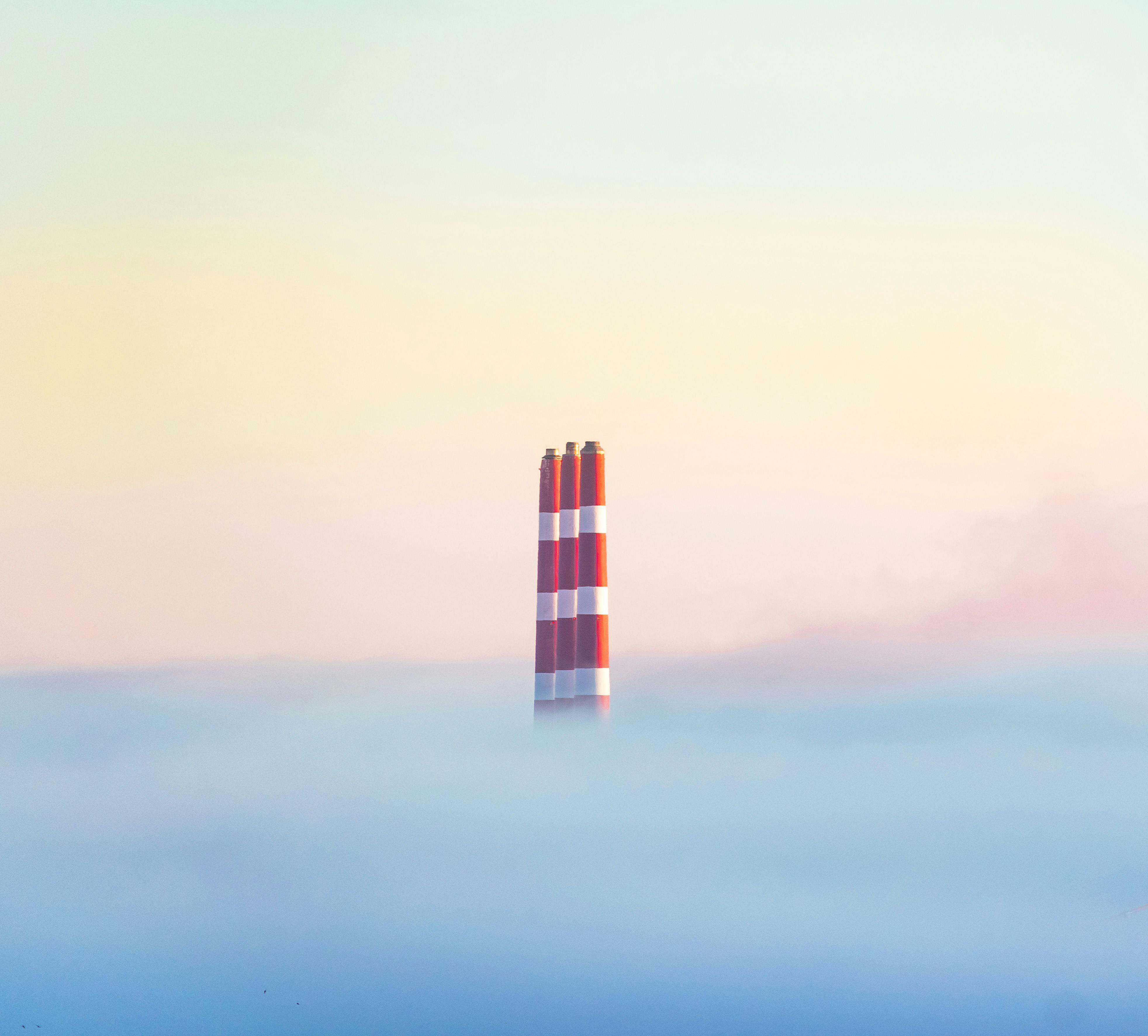 Minimalist view of chimneys emerging from fog in Halifax, showcasing soft pastel sky.