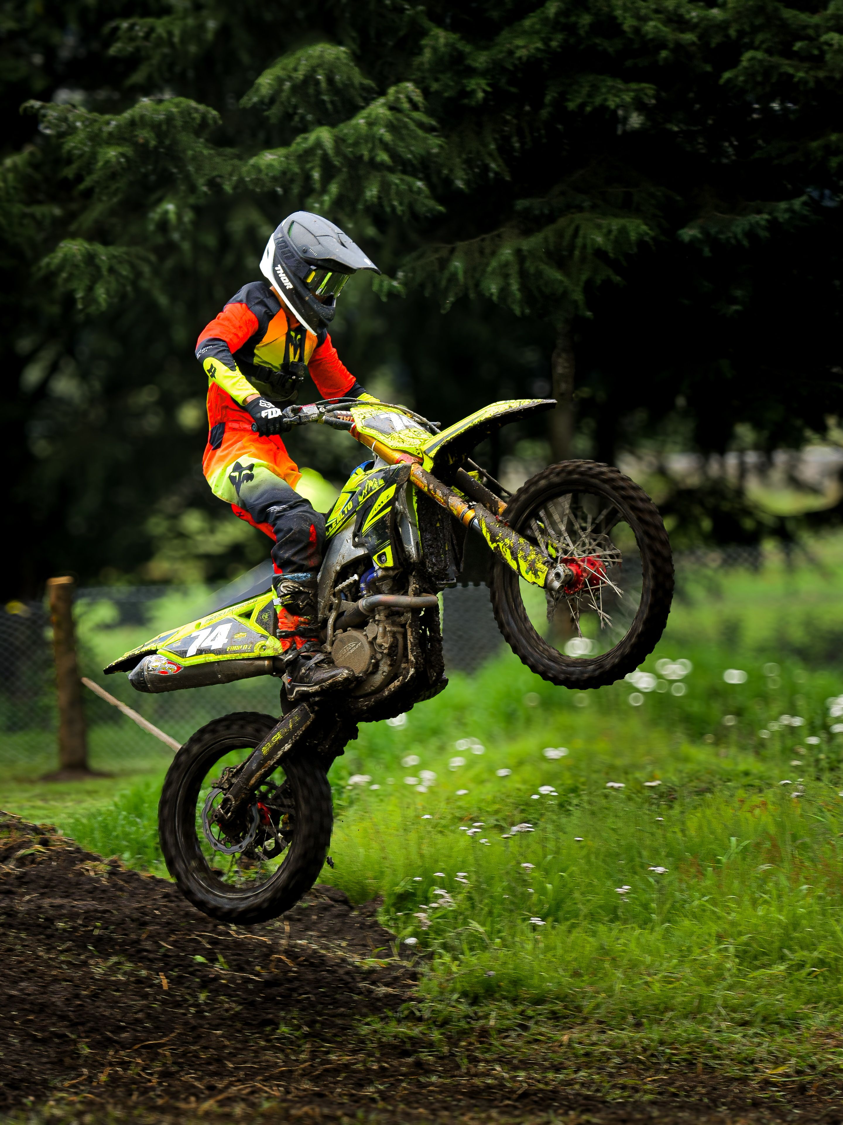 Dynamic shot of a motocross rider performing an acrobatic maneuver on a dirt track in México.