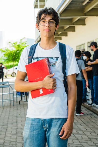 Estudiante latinoamericano sonriente con un cuaderno, listo para su regreso a clases