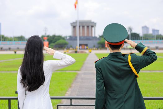 A couple saluting the Ho Chi Minh Mausoleum in Hanoi, Vietnam.