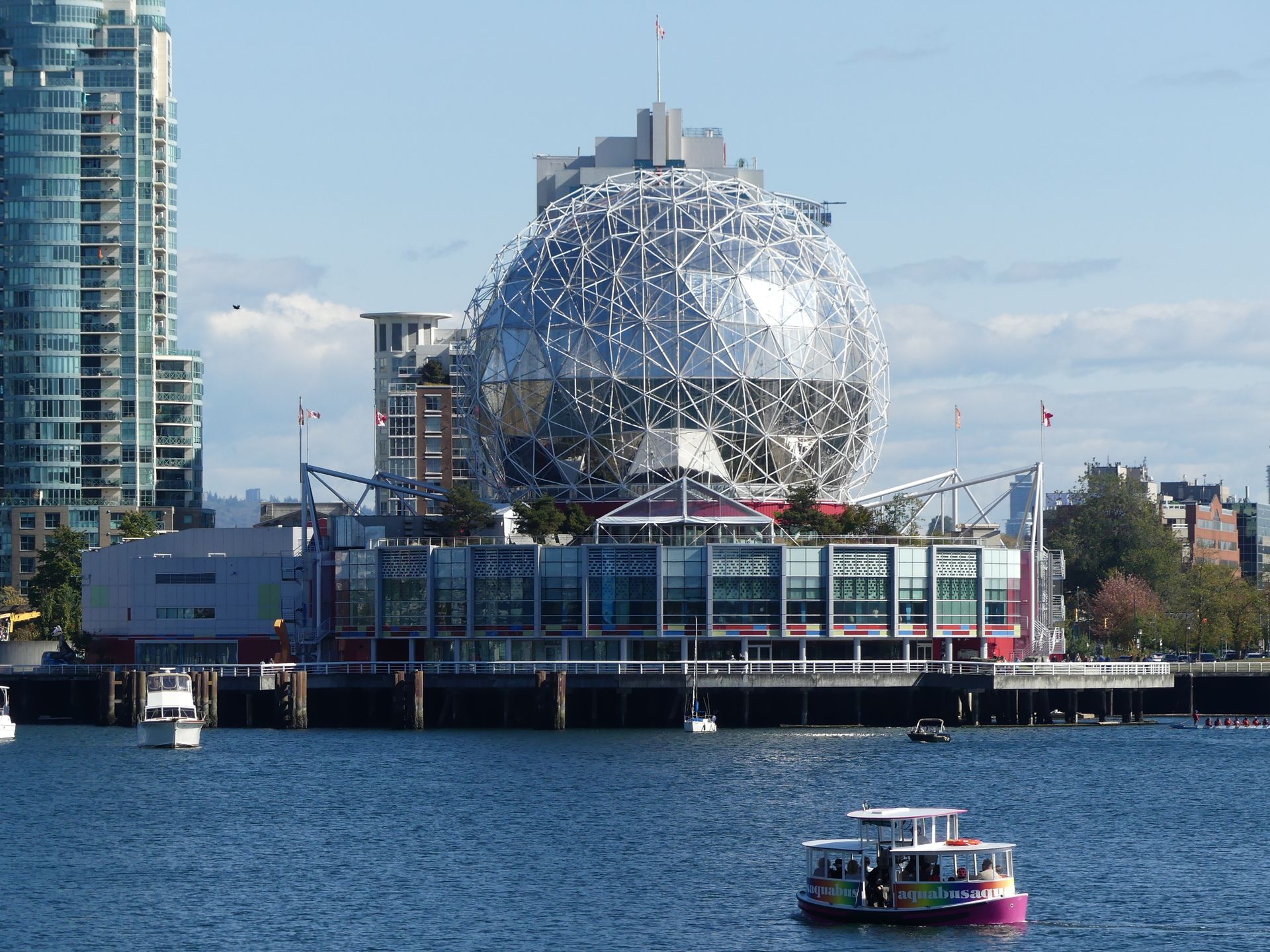 Telus World of Science with iconic geodesic dome on waterfront with boats.