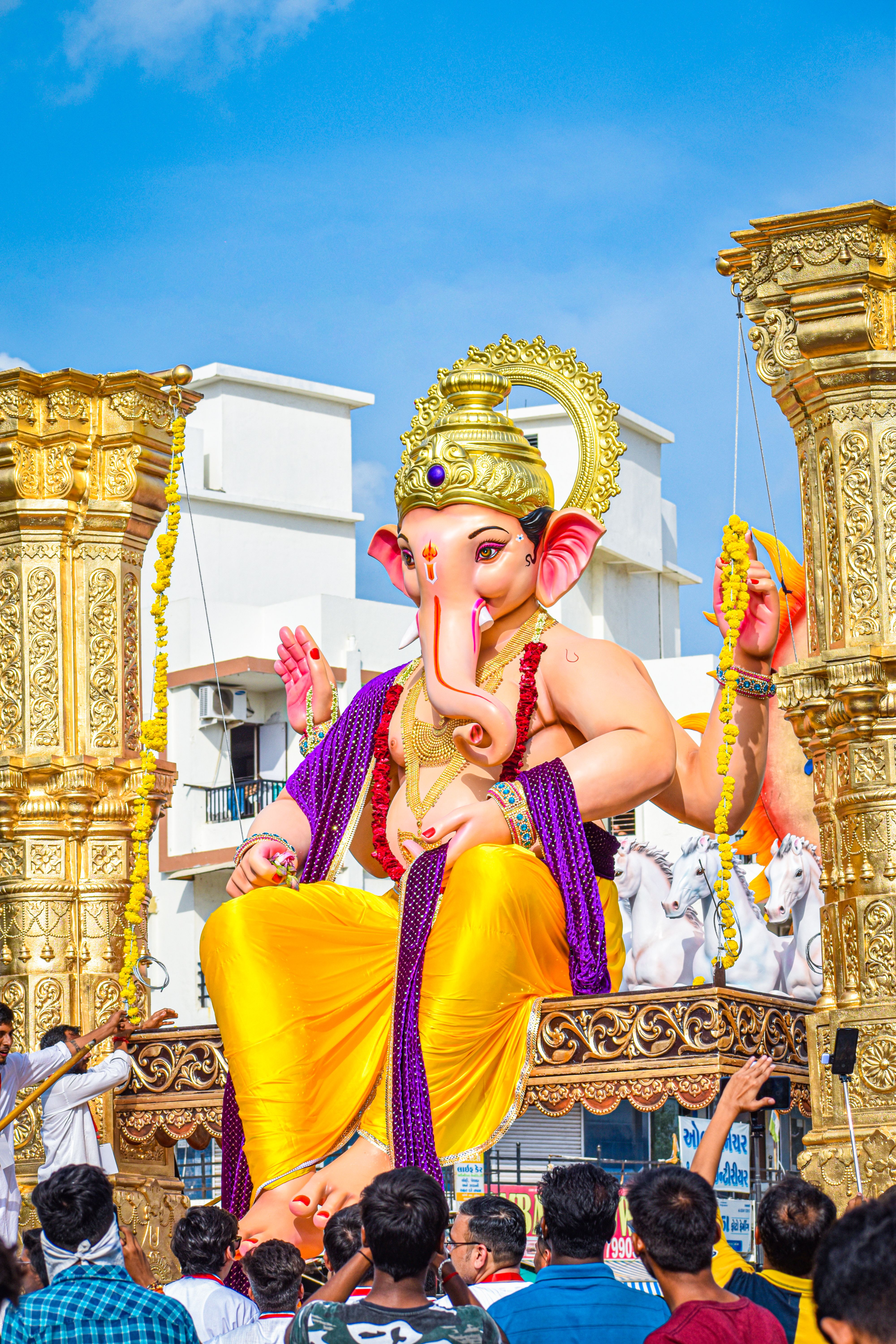 Colorful Ganesh Chaturthi festival procession with a large Ganesha idol in Vadodara, India.