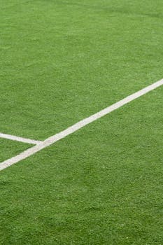 Detailed view of green artificial turf on a soccer field with white boundary lines.