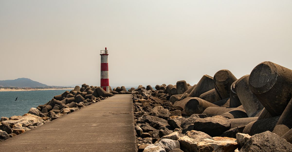 Scenic View of Lighthouse on Rocky Seafront Pathway · Free Stock Photo