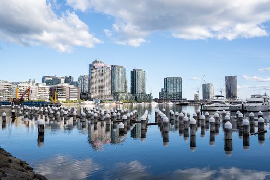 Discover the beauty of Melbourne's waterfront with its skyline reflecting in the calm waters, featuring modern architecture.