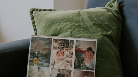 A vintage photo album displayed on a cozy armchair with green cushion, evoking nostalgia.