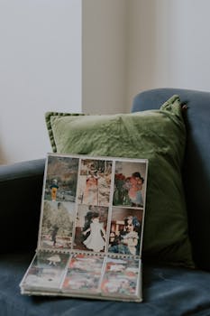 A vintage photo album displayed on a cozy armchair with green cushion, evoking nostalgia.