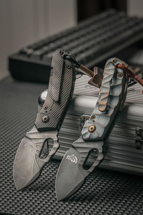 Free Detailed view of two modern tactical folding knives with textured handles on a metal surface. Stock Photo