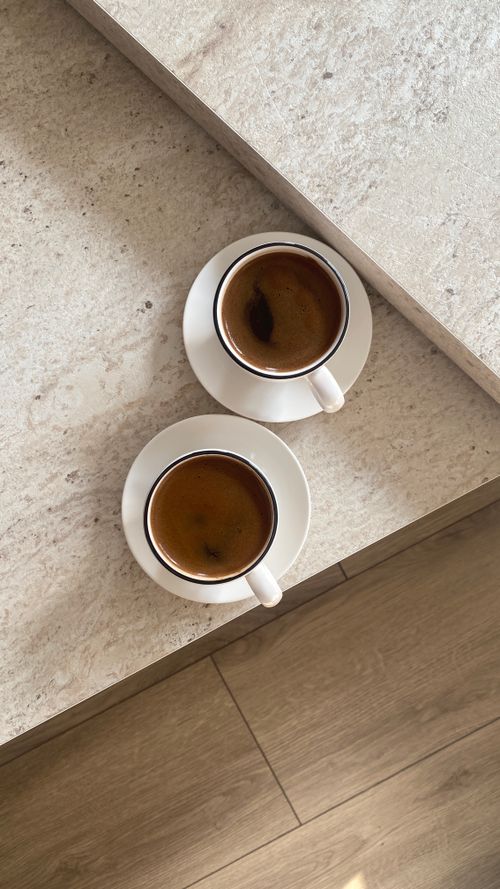 Free Two cups of espresso on marble, creating a minimalist and cozy atmosphere. Stock Photo
