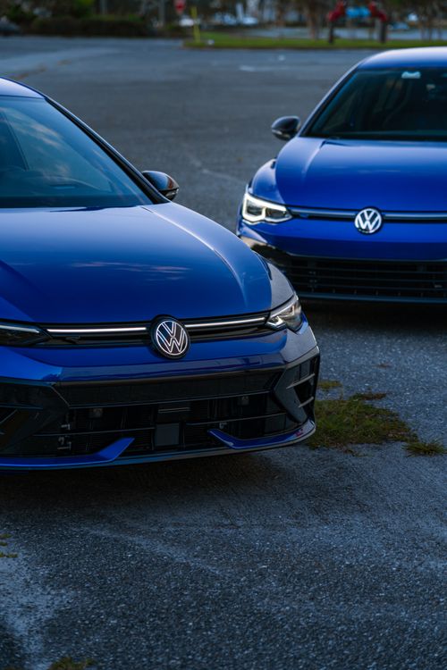 Free Two blue cars parked outdoors with a sleek design, captured at dusk. Ideal for automotive imagery. Stock Photo