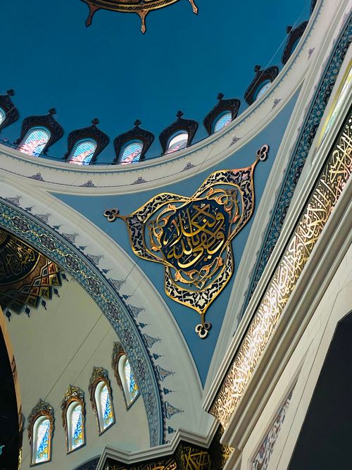 Free Elegant mosque dome interior with detailed Islamic calligraphy and geometric patterns. Stock Photo