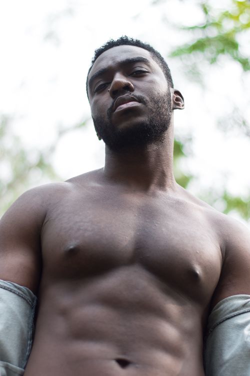 Free Portrait of a muscular shirtless man posing outdoors, expressing confidence and strength. Stock Photo