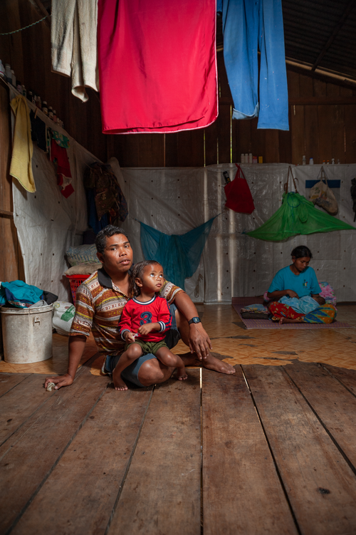 Free A family inside a rustic wooden house displaying daily life and cultural richness. Stock Photo