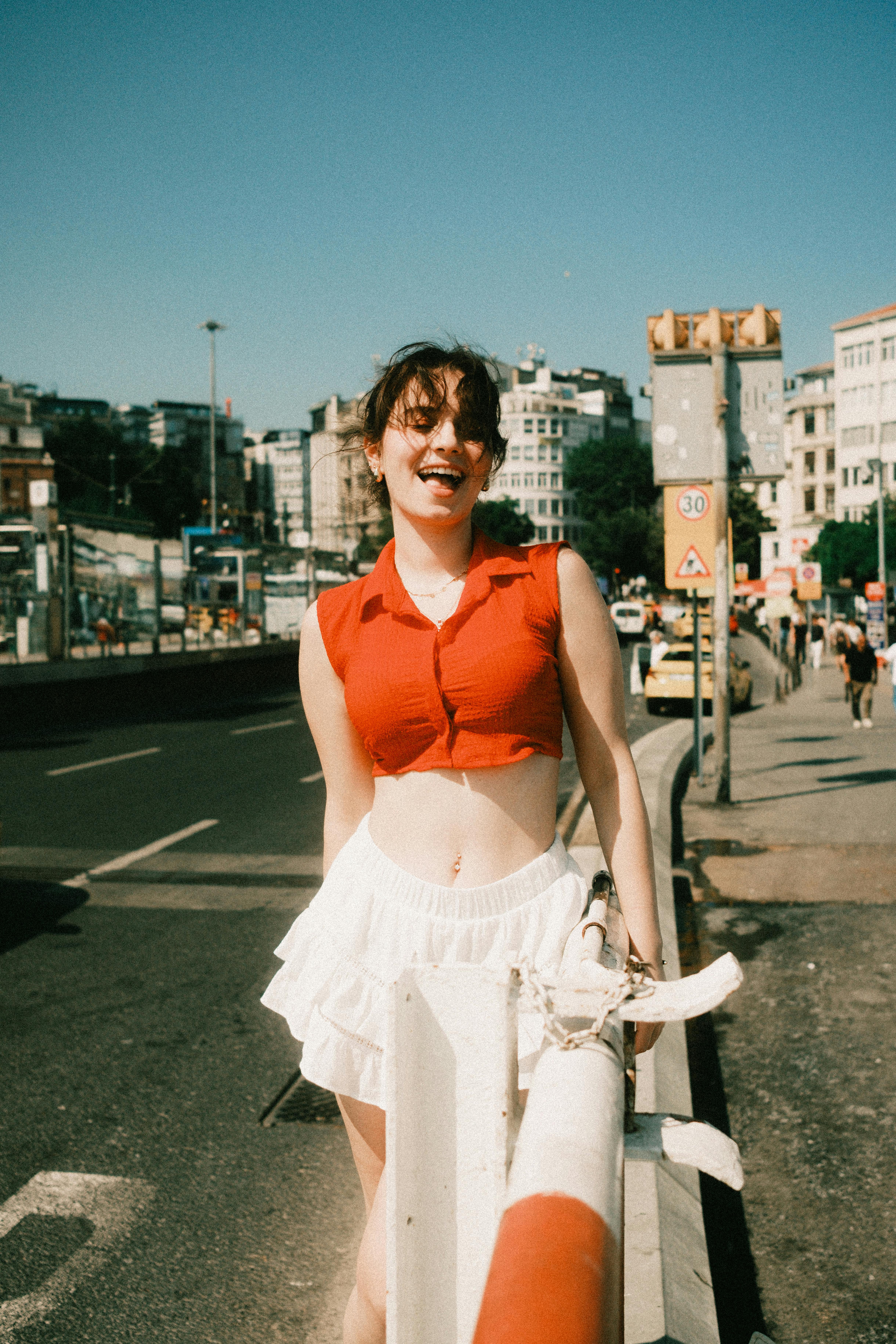 Happy young woman in casual summer outfit walking joyfully in the city.