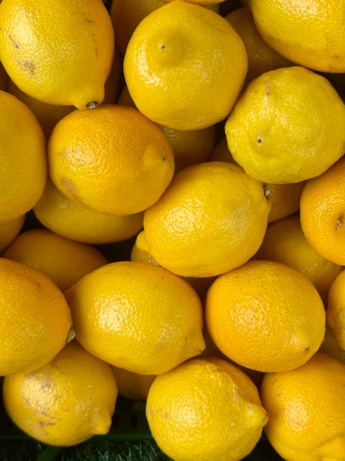 Free A vibrant close-up of fresh yellow lemons arranged tightly, showcasing their bright, zesty appearance. Stock Photo
