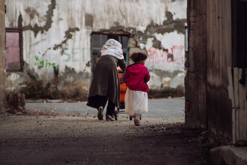 Free A mother and child in vibrant clothing walk through old streets in Erzurum, Türkiye. Stock Photo
