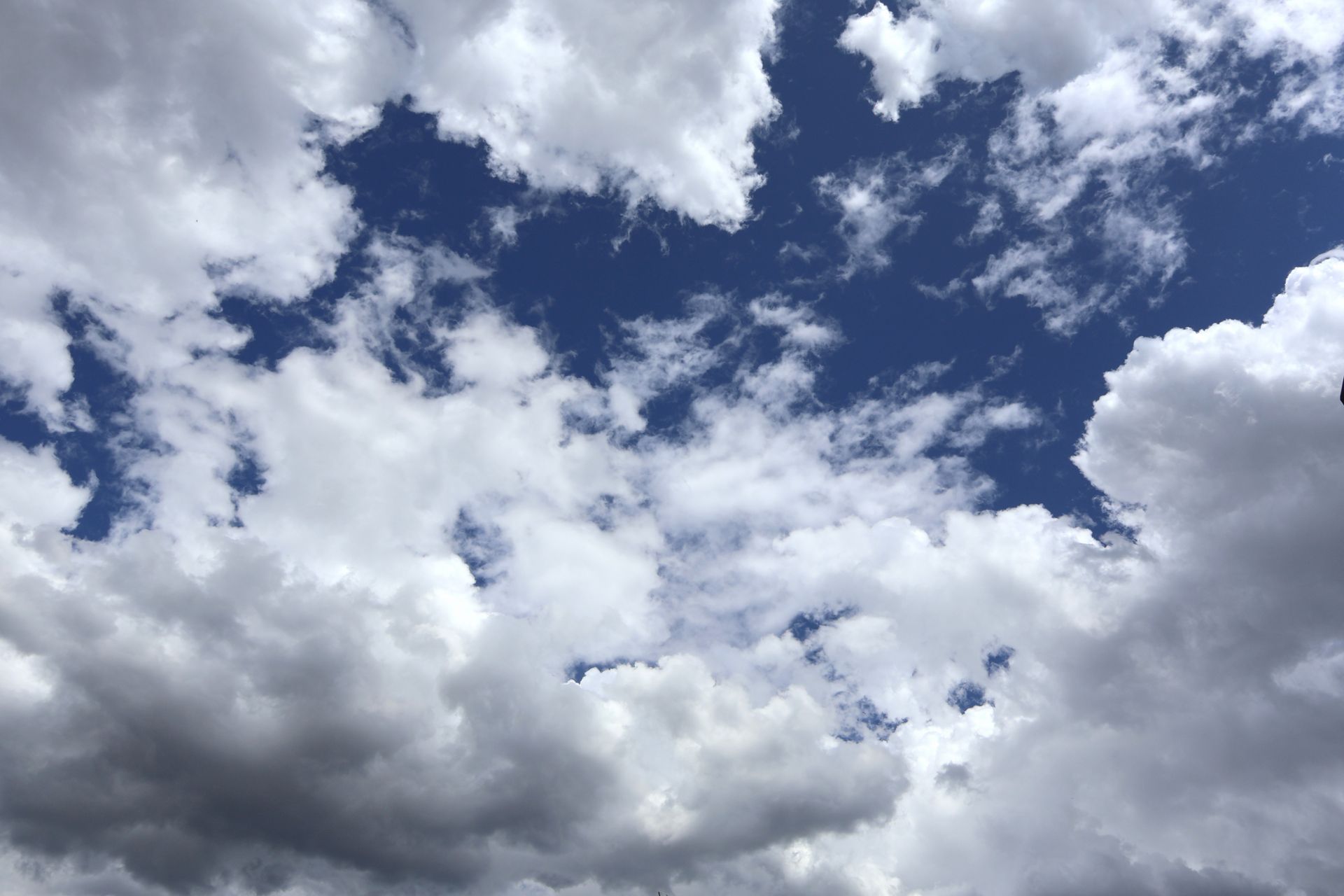 A scenic view of Milano's sky featuring fluffy white clouds against a vivid blue backdrop.