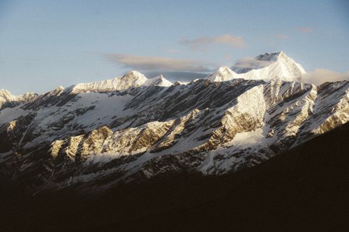 Free Stunning view of snow-covered mountains illuminated by sunrise light, capturing nature's beauty. Stock Photo
