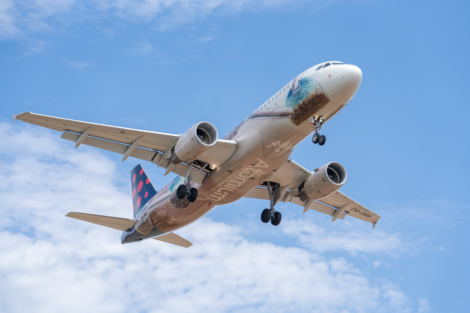 A commercial airliner with special livery captured mid-flight against a clear sky in Valencia, Spain.