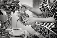 优雅的女士用复古银茶壶泡茶