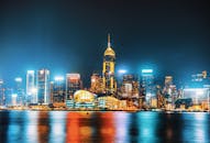 香港的夜间天际线生动迷人，以明亮的摩天大楼和海滨倒影为特色