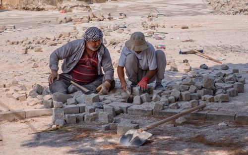 Free Hardworking road workers lay stones under the sun in Kozbeyli, İzmir, Türkiye. Stock Photo