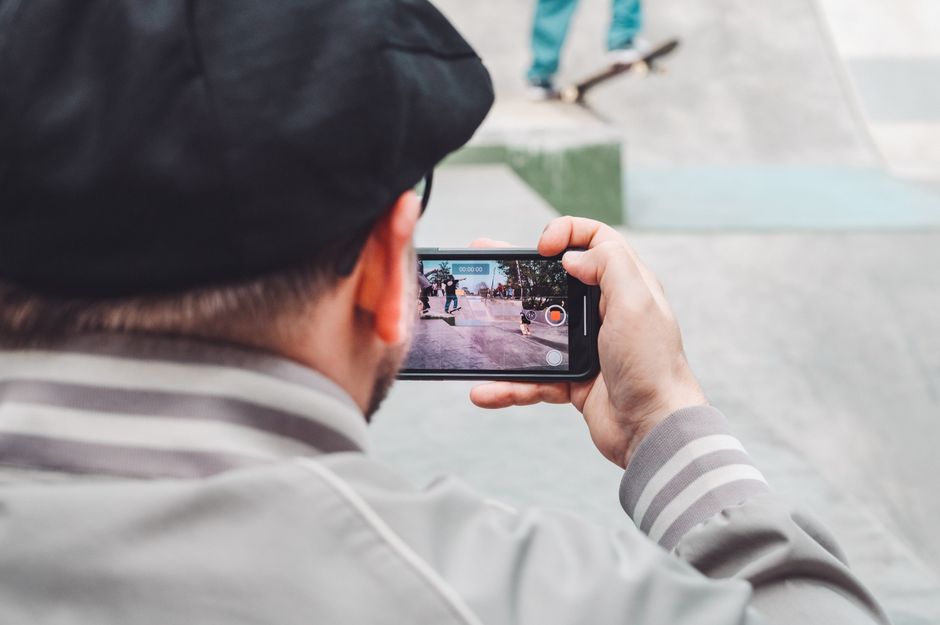 person recording street with phone