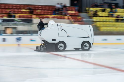 Free Ice resurfacer smoothing the rink during a break in an indoor stadium. Stock Photo