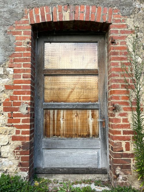 Free Old wooden door with glass panels in a weathered brick wall outdoors. Stock Photo