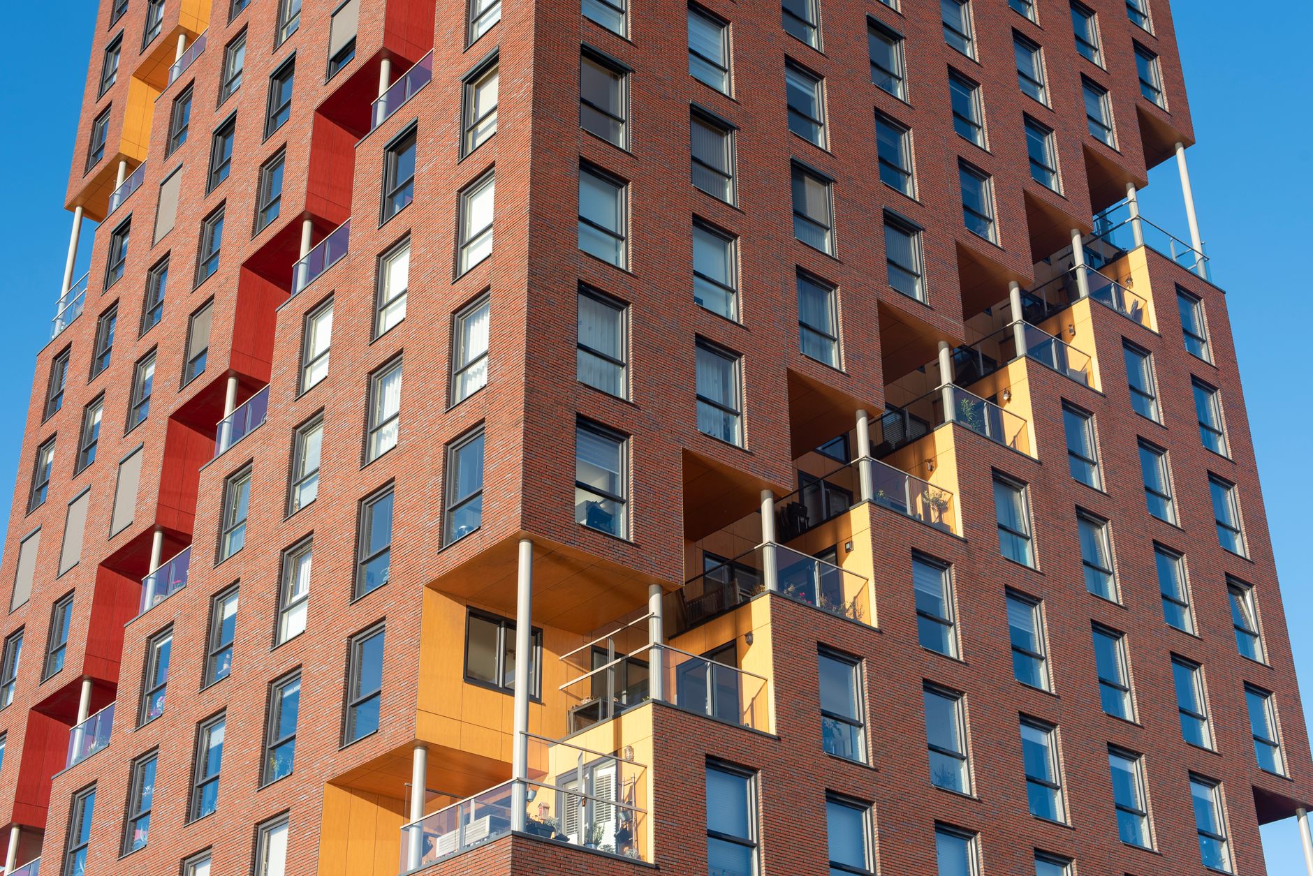 A low-rise residential apartment block seen from the street on a bright day