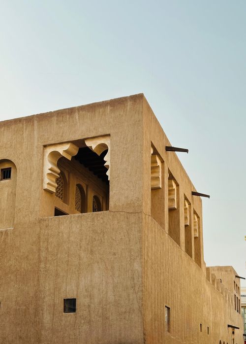 Free Rustic corner of a Middle Eastern building with traditional stone arches under a clear sky. Stock Photo