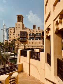 Beautiful Arabesque architecture with a view of the iconic Burj Al Arab in sunny Dubai.