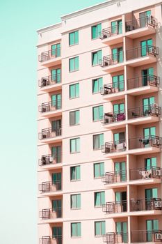 Contemporary apartment building facade with multiple balconies under a clear sky.