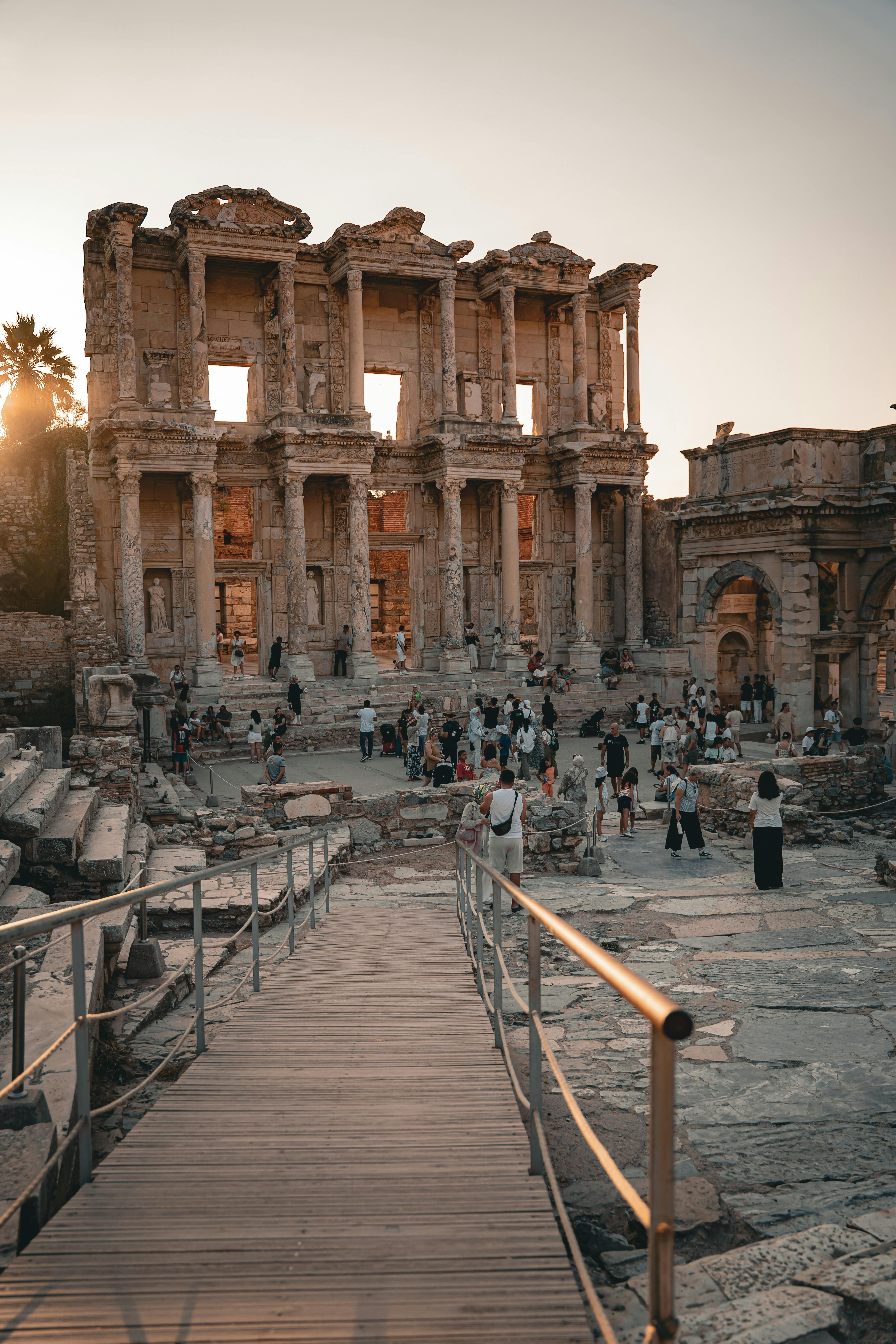 Discover the historic Celsus Library with visitors at sunset, capturing its ancient architecture.