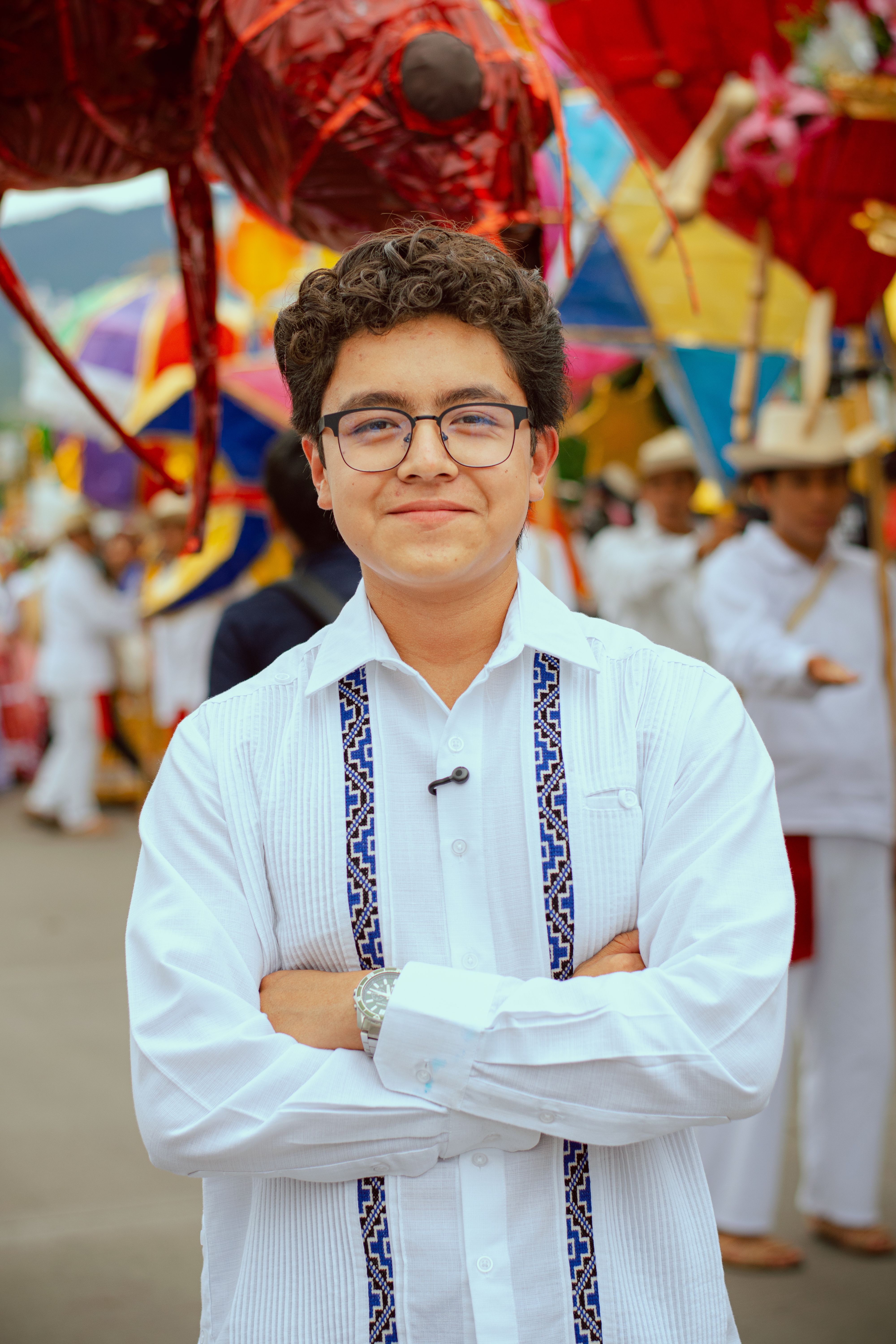 Young man smiling at a vibrant Oaxaca festival in traditional wear. Celebrating local culture.