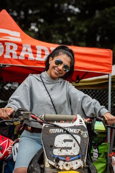 Woman enjoys motocross event, smiling on a dirt bike in La Marquesa, Mexico.