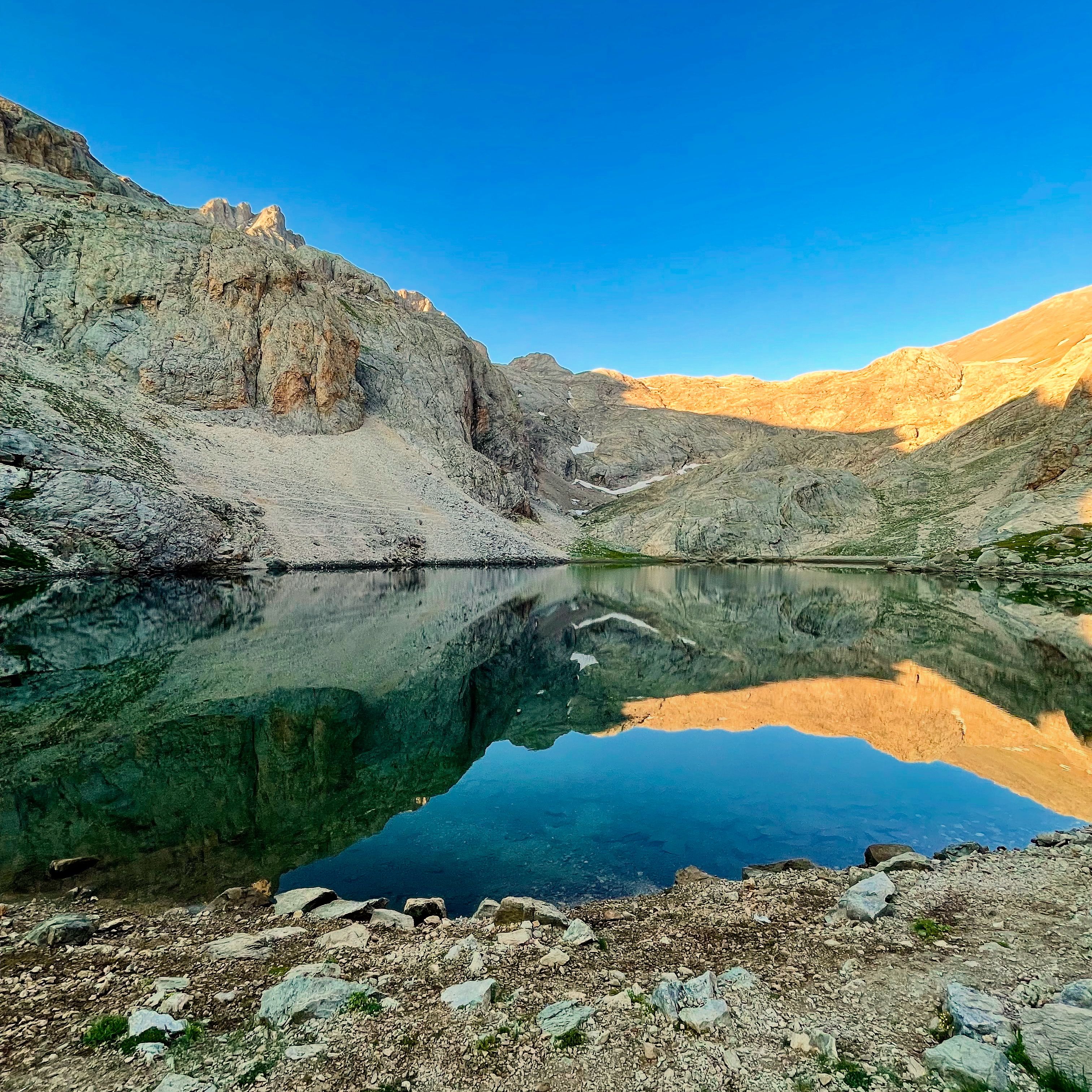 Turquoise water against a scree slope, photo by Eren Sever on Pexels