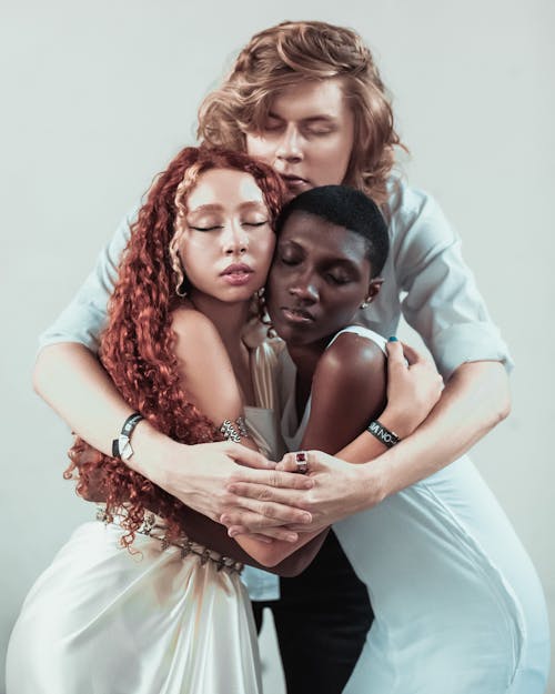 Free Man Hugging Two Women While Standing Stock Photo