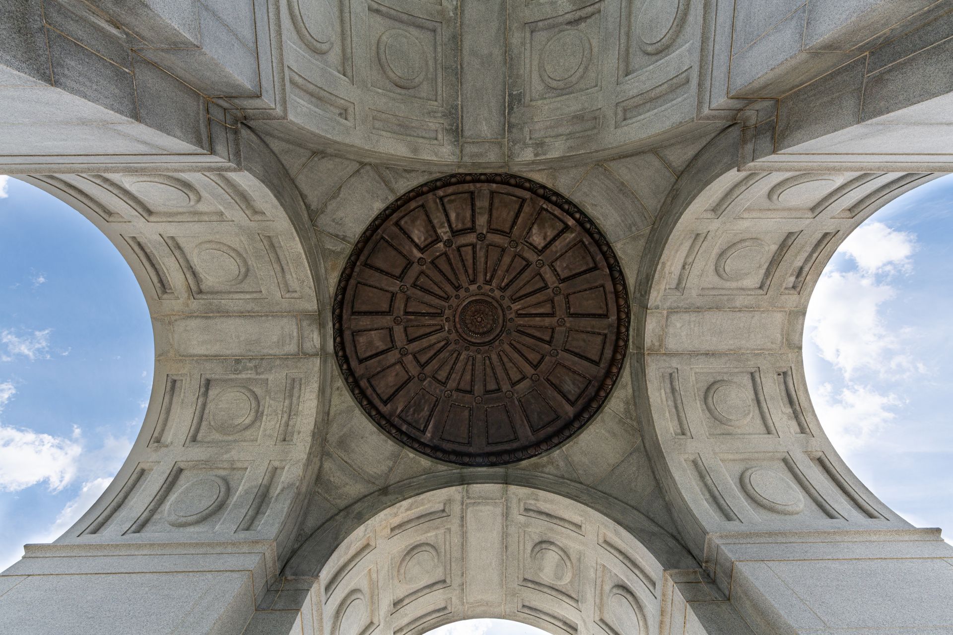 Dramatic underside view of a stone memorial arch in Gettysburg, capturing architectural details.