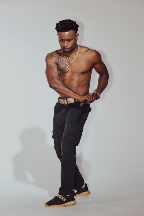 Free Shirtless man displaying tattoos in a fashion pose, highlighting body art and style. Stock Photo