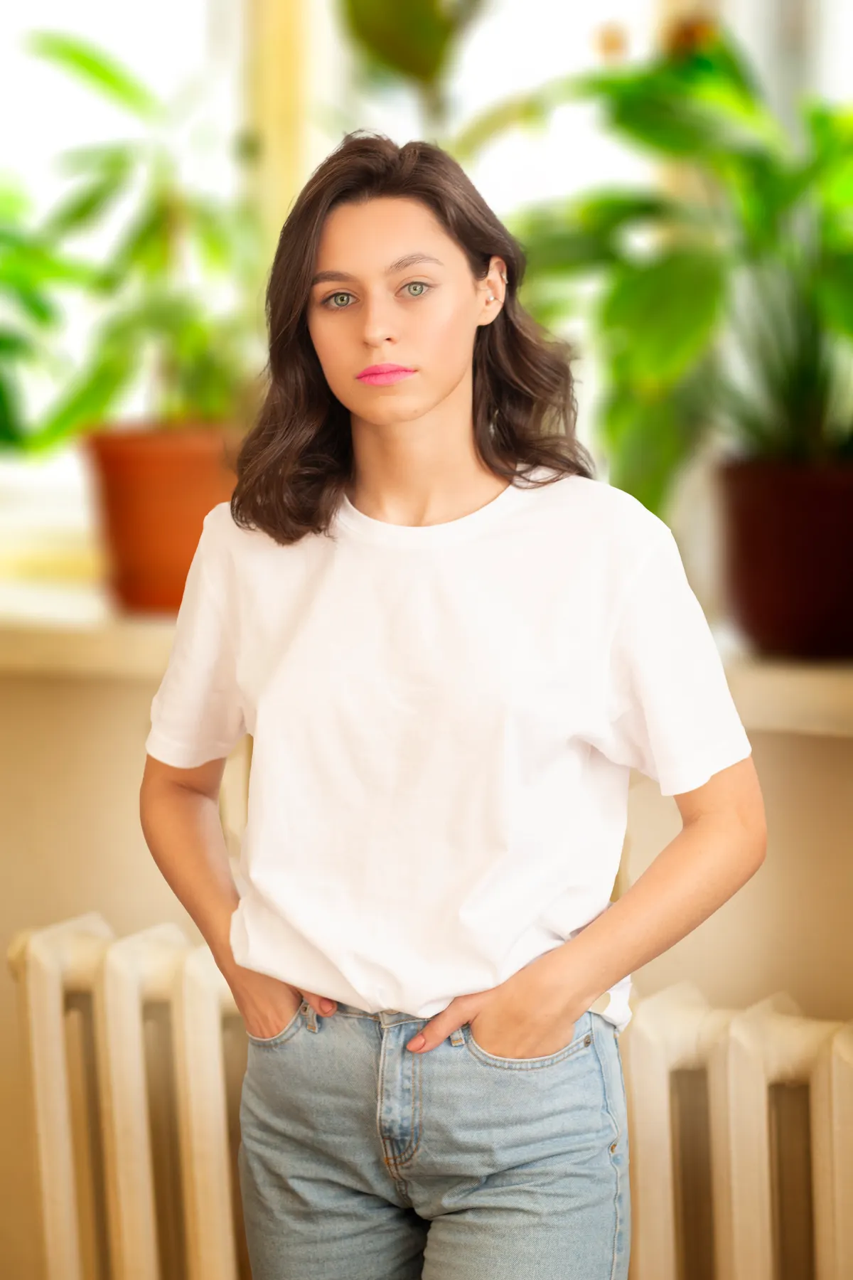 Woman in white tee and jeans, plants in background