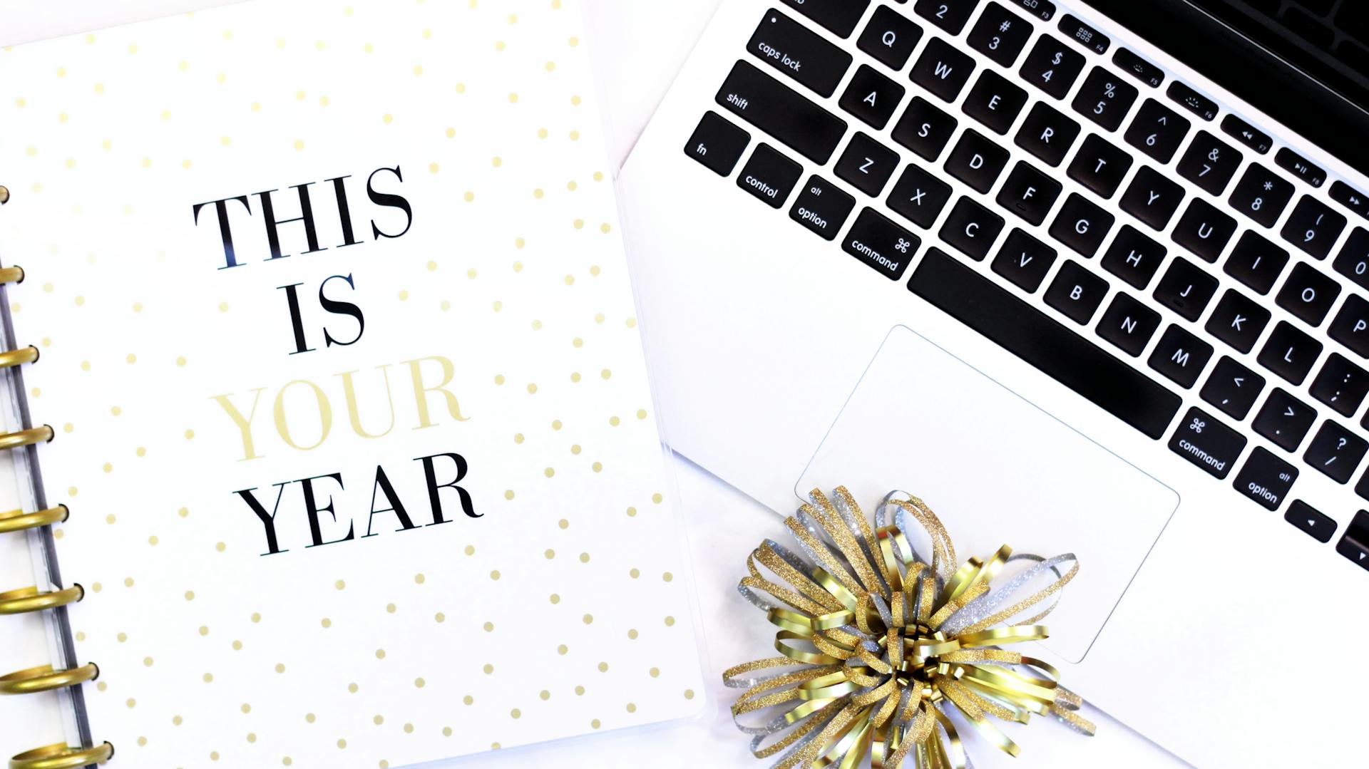 A stylish desk setup featuring a laptop and a motivational notebook for productivity inspiration.