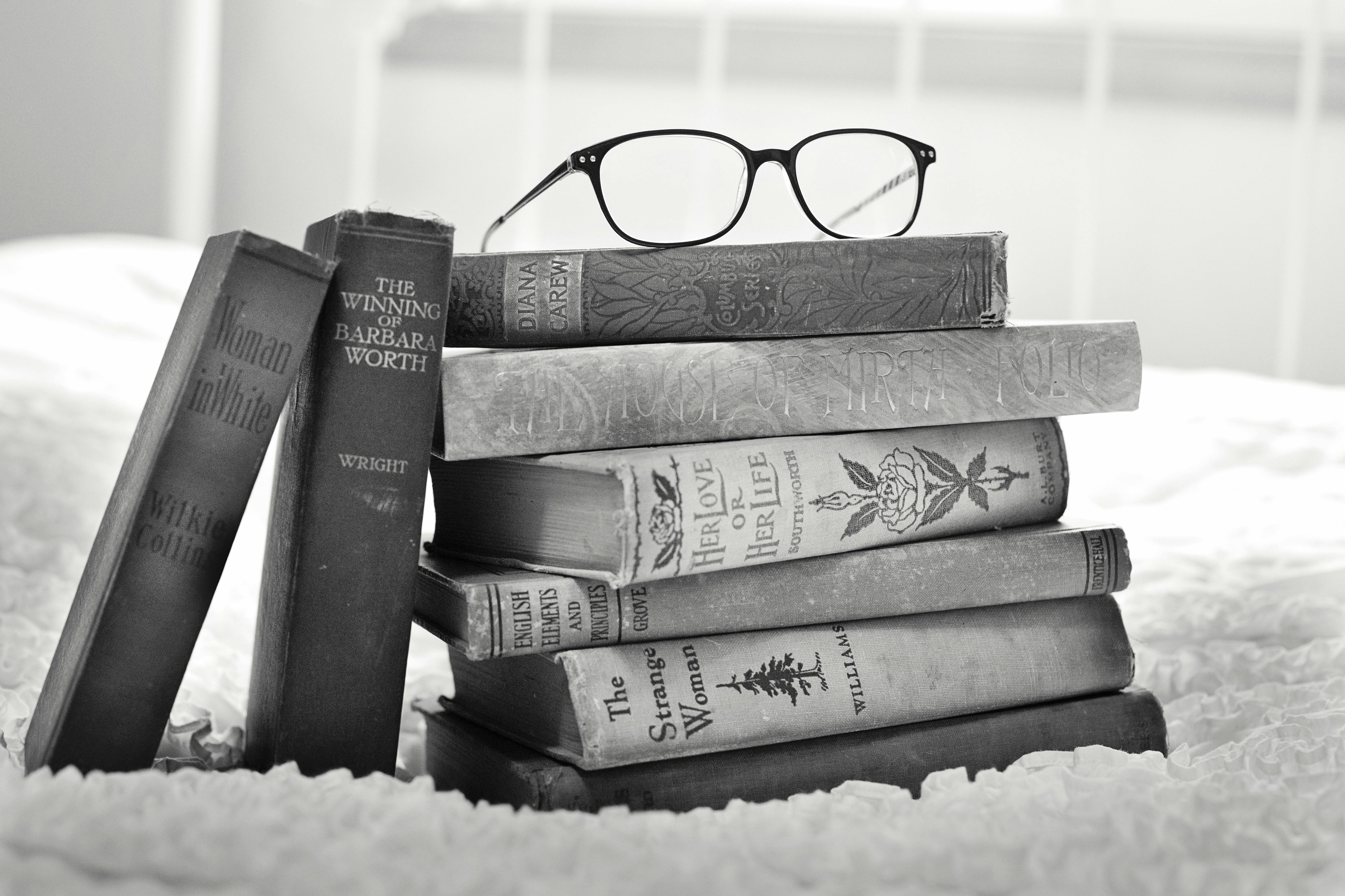 Grayscale Photo Of Eyeglasses On Pile Of Books Free Stock