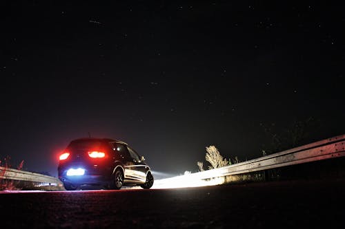 Бесплатное стоковое фото с автомобиль, задний свет, звездная ночь
