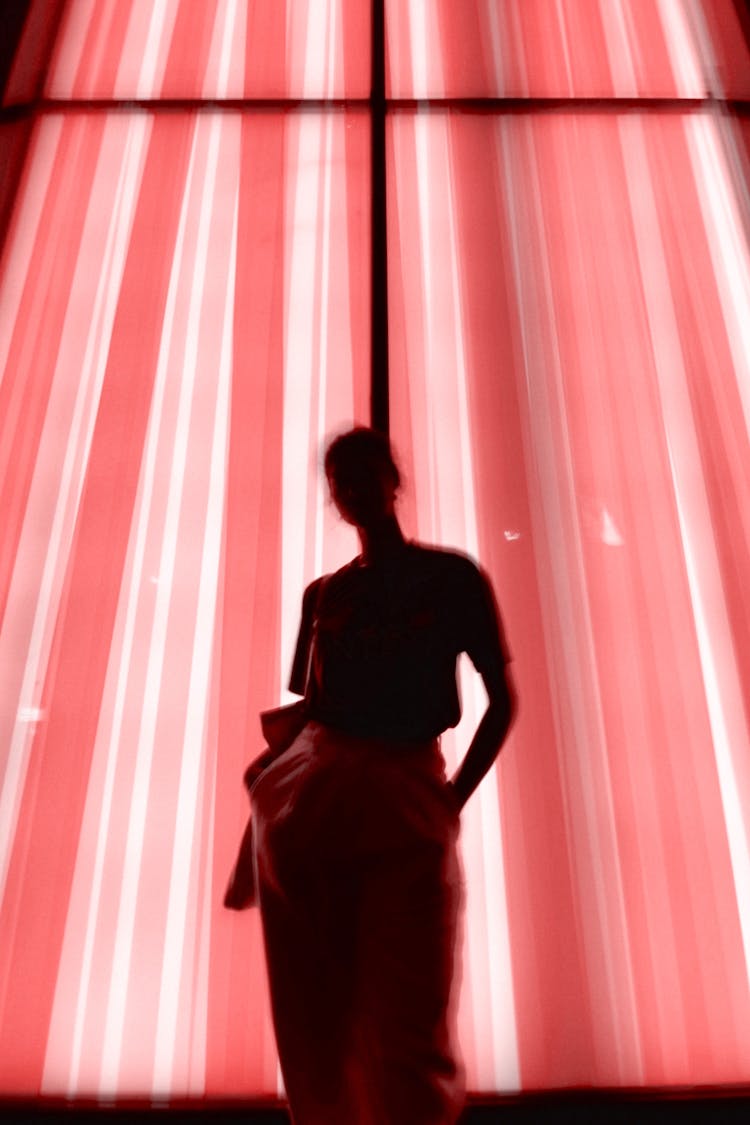 Woman Standing Beside Window With Pink Curtain