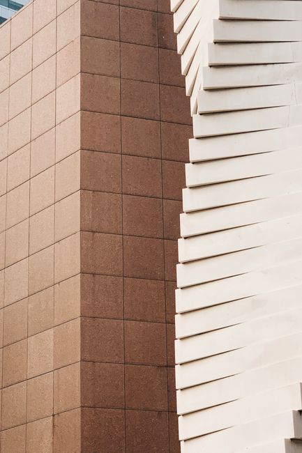 Close-up of contemporary urban building facade with contrasting textures and geometric shapes.