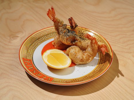 Delicious tempura shrimp with lemon on a designer Versace plate.